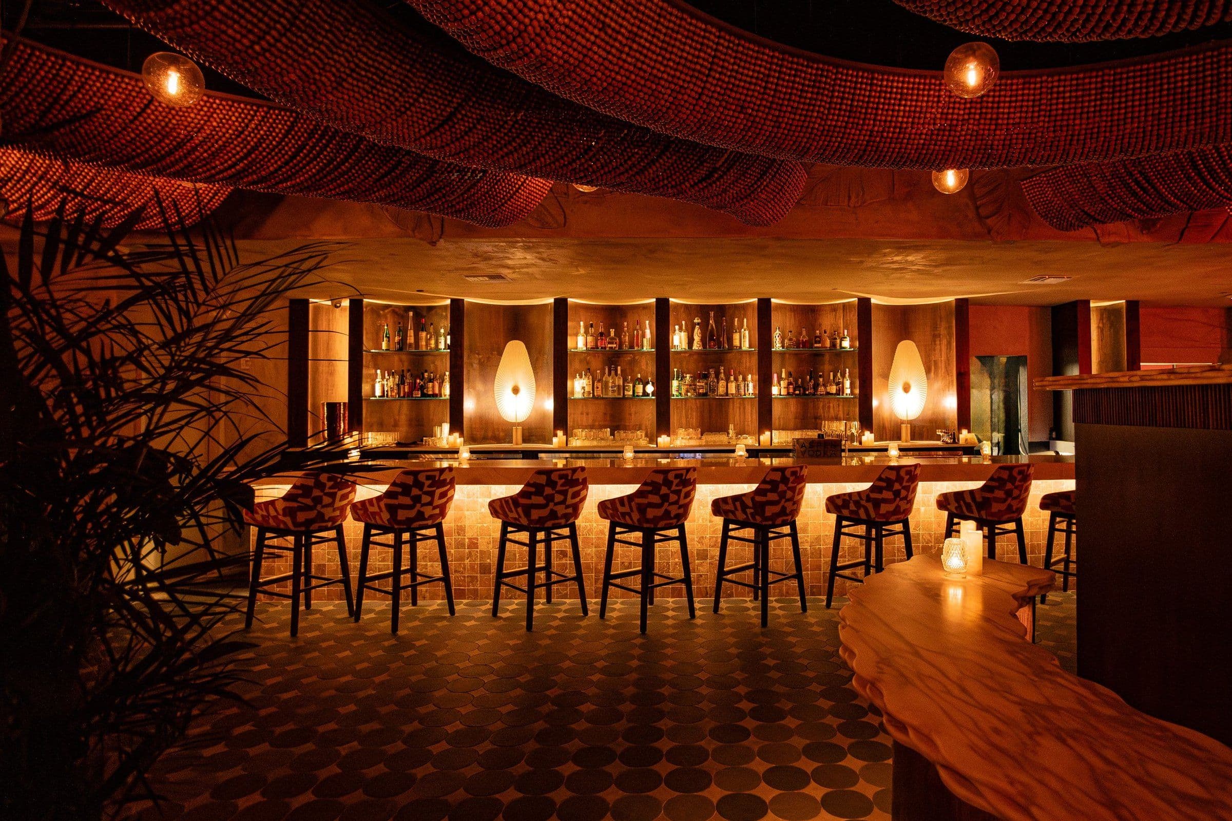 KIRA's bar: rope-lit ceiling, amber pendant lights and a row of patterned bar stools