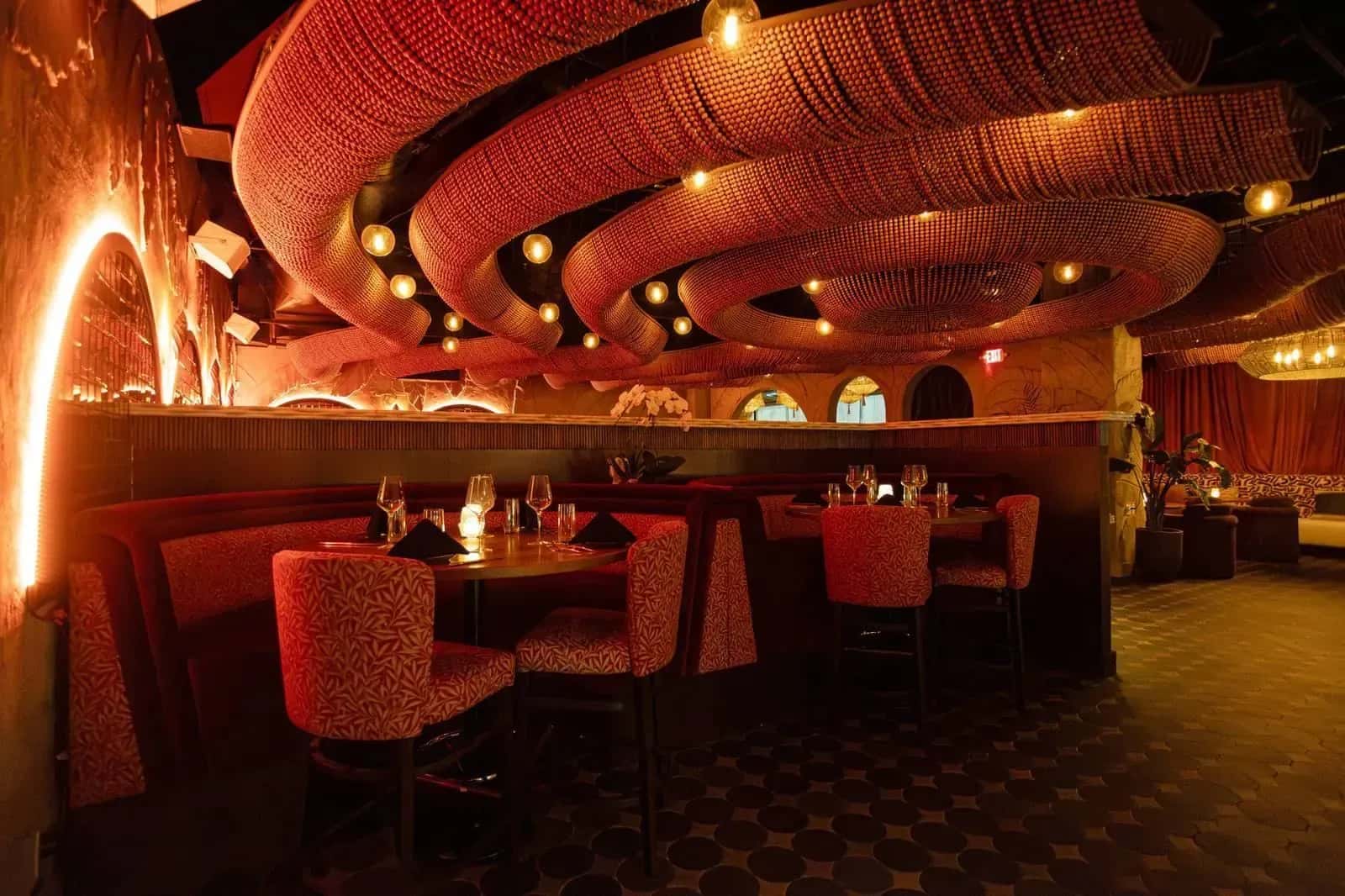The upper dining room at KIRA, lit under sculptural arches