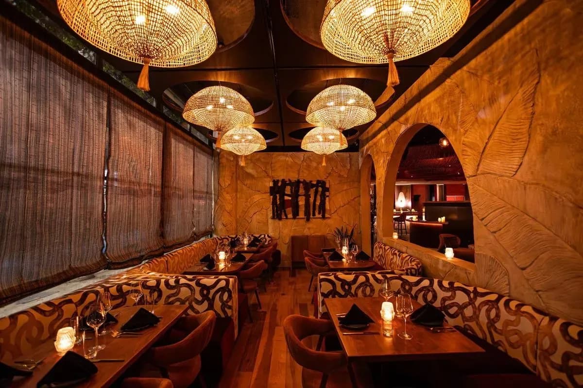 The lower dining room under woven pendant lights